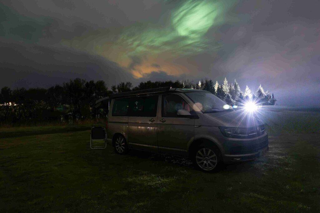 VW California older parked under the aurora