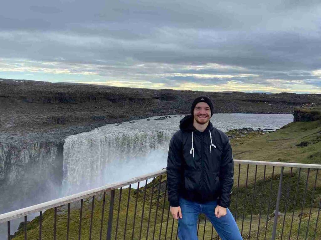 A man standing by a waterfall