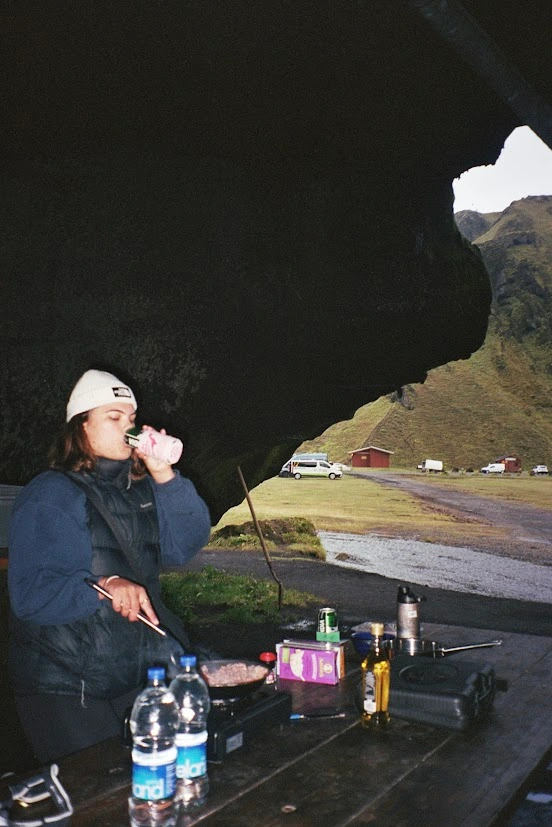 A girl cooking in a cave and drinking