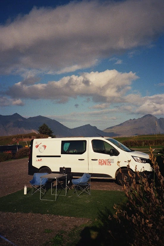A trafic camper at a campsite, camping table set up